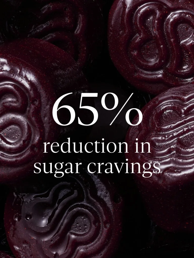 Sakara Metabolism Bite thermogenic gummies clinical graphic over close-up background of dark red gummies stating 65% reduction in sugar cravings after 8 weeks