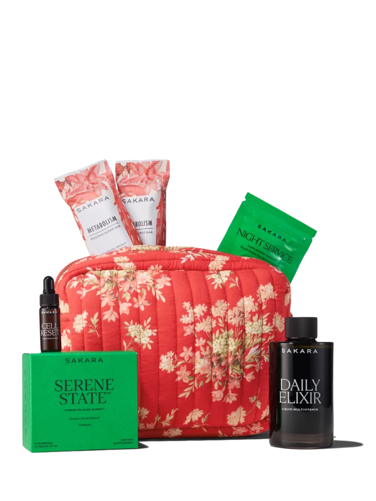 Sakara x DÔEN Holloway Pouch in red quilted floral cotton shown with Daily Elixir liquid multivitamin deluxe sample 3.25 fl oz, Cell Reset deluxe sample 0.17 fl oz, Serene State gummies 3 packs of 2, Night Service deluxe sample 6 capsules, and 2 Metabolism Protein Super Bars 45g each.