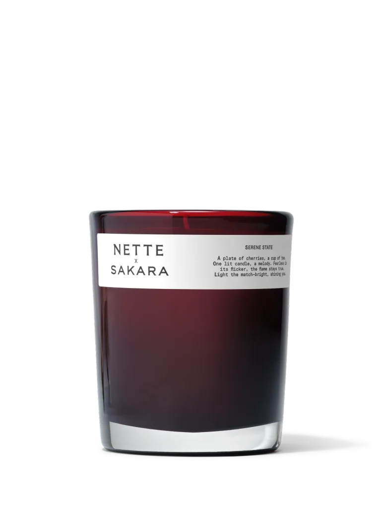 Sakara x Nette Serene State Scented Candle in deep red translucent glass vessel with white label reading Serene State and Limited Edition badge displayed.