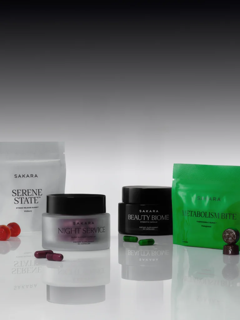 The Sakara Life Best Sellers Bundle including Metabolism Bite, Beauty Biome, Serene State, Night Service; Gummies and pills beside each package; image of packaging on a grey ombre background