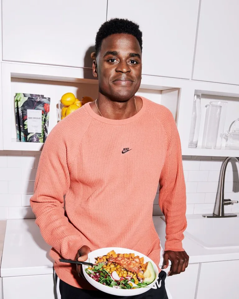 Joe Holder in a kitchen holding a bowl of food.