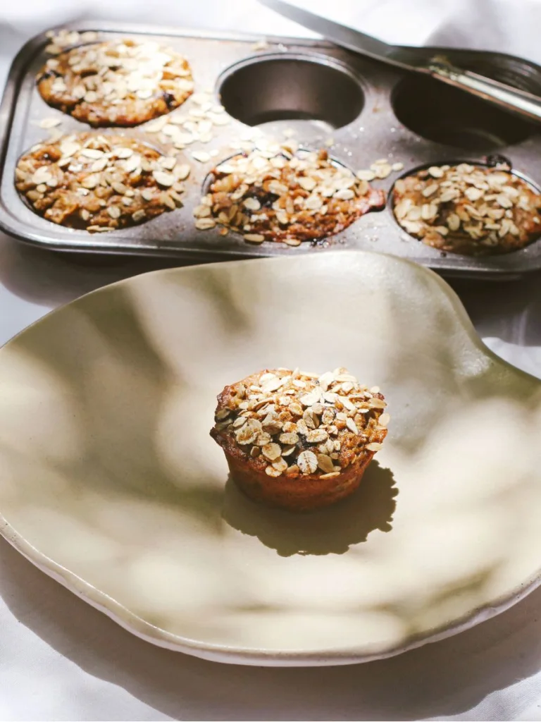 A tin with baked muffins covered with oats, made with Protein + Greens Super Powder.